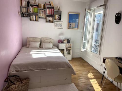 une chambre avec un lit, un bureau et une fenêtre dans l'établissement Levallois SO-Ouest Charme & Cosy, à Levallois-Perret