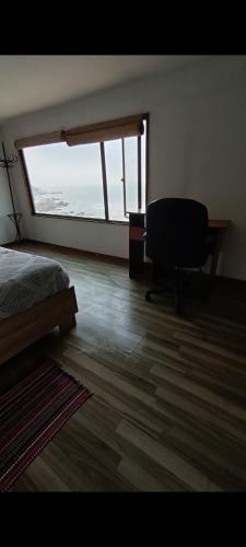 um quarto com uma cama, uma secretária e uma janela em Casa playa ConCon em Concón