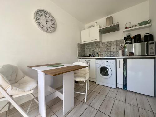 une cuisine avec une table et une machine à laver dans l'établissement Studio avec terrasse-Orange Vélodrome, à Marseille