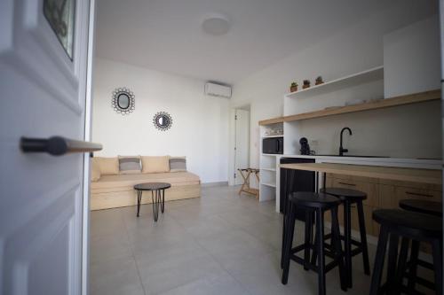eine Küche und ein Wohnzimmer mit einem Bett und Stühlen in der Unterkunft Kotinos Luxury Suites in Skyros