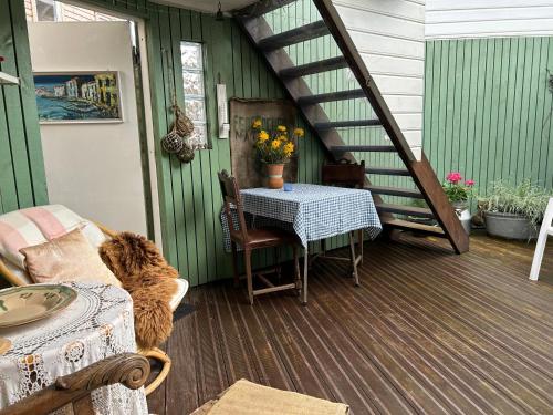 Charming studio with private patio في ستافانغر: كلب يجلس على شرفة مع طاولة