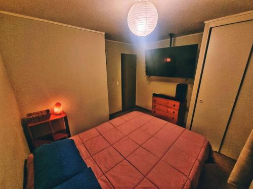 a bedroom with a bed and a dresser and a lamp at Departamento Equipado Parejas in Coquimbo