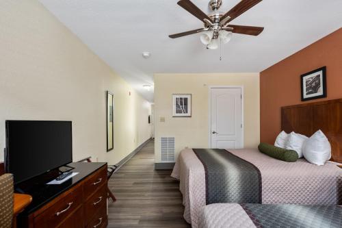 a hotel room with two beds and a flat screen tv at Affordable Suites of America Stafford Quantico in Stafford