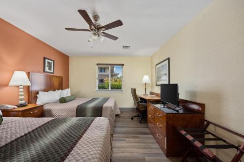 Habitación de hotel con 2 camas y ventilador de techo. en Affordable Suites of America Stafford Quantico, en Stafford