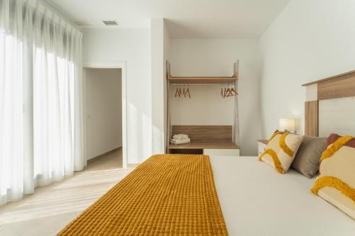 a bedroom with a large bed with a yellow rug on it at CMDreams Platinium- Apartamentos turísticos en el centro de Mérida in Merida