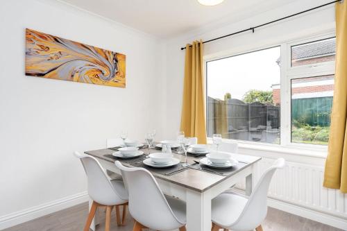 a dining room with a table and chairs and a window at Spacious Modern Home in Sheffield in Todwick