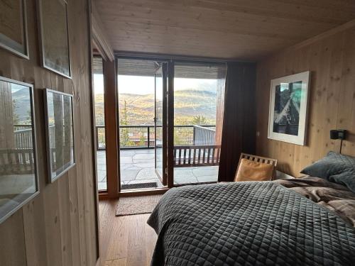 a bedroom with a bed and a view of a balcony at Astonishing Mountain Lodge at the top of Gaustablikk, 25m2 west facing terrace, 3 bedrooms in Gaustablikk