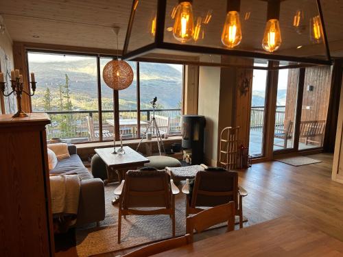 a living room with a view of a mountain at Astonishing Mountain Lodge at the top of Gaustablikk, 25m2 west facing terrace, 3 bedrooms in Gaustablikk