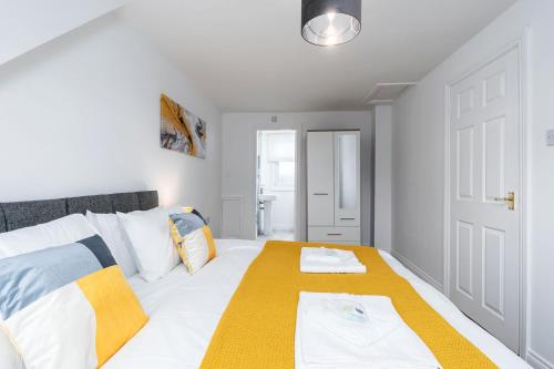 a bedroom with a bed with a yellow blanket on it at Spacious Modern Home in Sheffield in Todwick