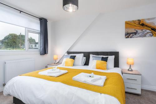 a bedroom with a large bed with two towels on it at Spacious Modern Home in Sheffield in Todwick