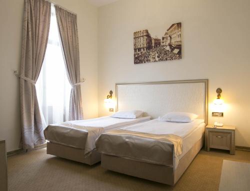 a bedroom with two beds and a large window at Euro Hotel Grivita in Bucharest