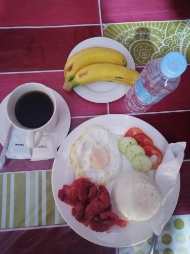 a plate of breakfast food with a cup of coffee and bananas at Sang Yoo Mountain View Tagaytay Bed and Breakfast - Taal Lake View in Tagaytay