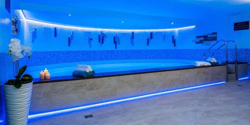 ein großes Badezimmer mit einer Badewanne mit blauer Beleuchtung in der Unterkunft WX Hotel in Bratislava