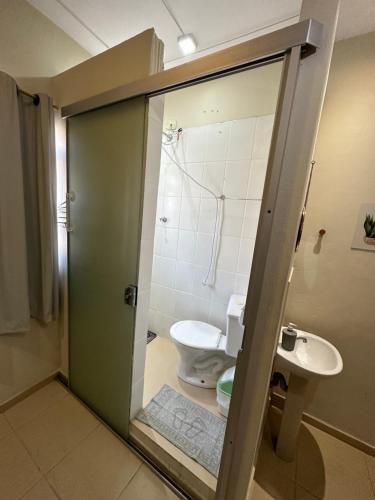 a bathroom with a toilet and a sink at POUSADA CASA DA FÉ in Aparecida