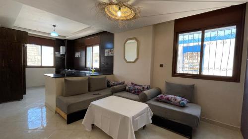 Appartement au coeur d'Aourir في أورير: غرفة معيشة مع أريكة وطاولة