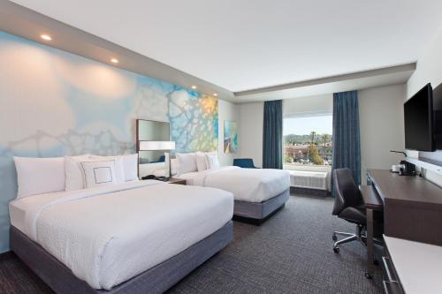 a hotel room with two beds and a desk at Courtyard by Marriott San Diego El Cajon in El Cajon