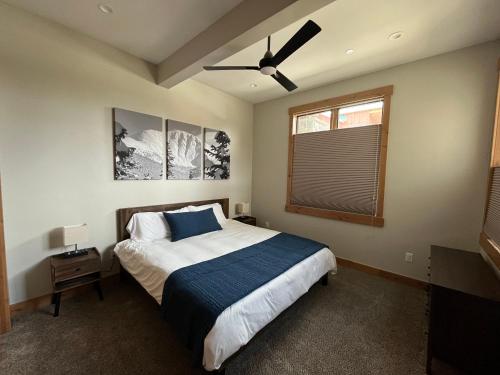 a bedroom with a bed and a ceiling fan at Brand New! Private hot tub, bunk room and walkable to restaurants/shops in Fraser