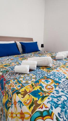Una cama grande con una manta colorida. en Laperlapartment, en San Leone