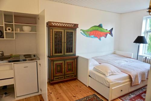 a small bedroom with a bed and a kitchen at Old Roses Guesthouse in Broager