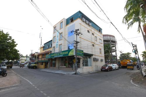 a building on the corner of a street with cars parked at PLEASANT STAYS Hotel in Chennai