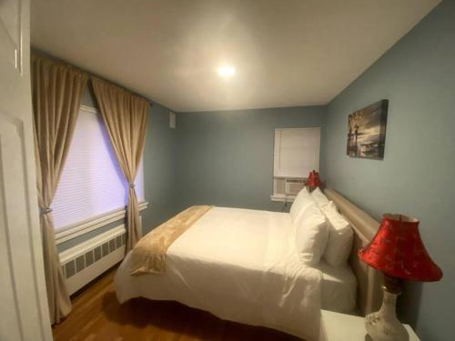 - une chambre avec un lit blanc et une fenêtre dans l'établissement Cozy Boston Getaway Apartment, à Boston