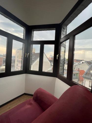 a living room with a couch in front of windows at City Appartement A zur ewigen Lampe dritte Etage in Brühl
