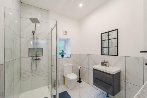 a bathroom with a shower and a toilet and a sink at Augusta lodge Moseley in Birmingham