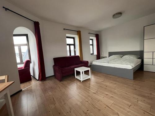 ein Schlafzimmer mit einem Bett, einem Sofa und einem Stuhl in der Unterkunft City Appartement A zur ewigen Lampe dritte Etage in ein historisches Denkmalschutz mit Garage in Brühl