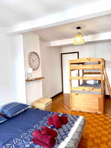 une chambre avec un lit et une horloge au mur dans l'établissement 3-CosyT2 à l'ancienne proche place Carnot BOX A BAGAGES GRATUITS, à Carcassonne