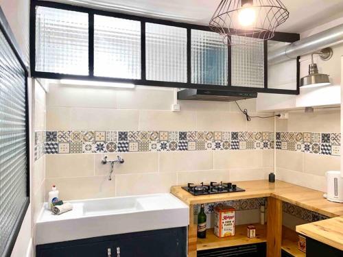 une cuisine avec un évier et une cuisinière dans l'établissement 3-CosyT2 à l'ancienne proche place Carnot BOX A BAGAGES GRATUITS, à Carcassonne