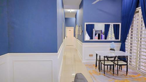 un couloir avec une table et un mur bleu dans l'établissement Homestay By MSH, à Seri Iskandar