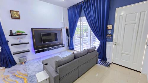 ein Wohnzimmer mit einem Sofa und einem TV in der Unterkunft Homestay By MSH in Seri Iskandar