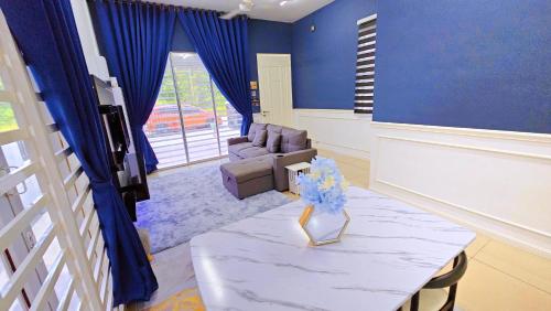 a blue living room with a table and a couch at Homestay By MSH in Seri Iskandar