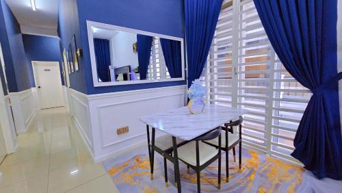 een blauwe kamer met een tafel en een spiegel bij Homestay By MSH in Seri Iskandar