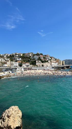 Une plage avec un tas de gens dans l'eau dans l'établissement Douceur entre Notre Dame et la mer, à Marseille