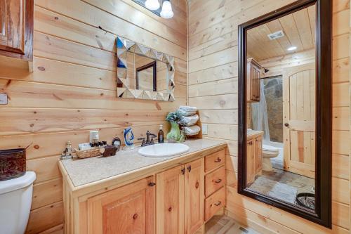 a bathroom with a sink and a toilet and a mirror at Fort Towson Cabin Less Than 1 Block to Raymond Gary Lake in Fort Towson