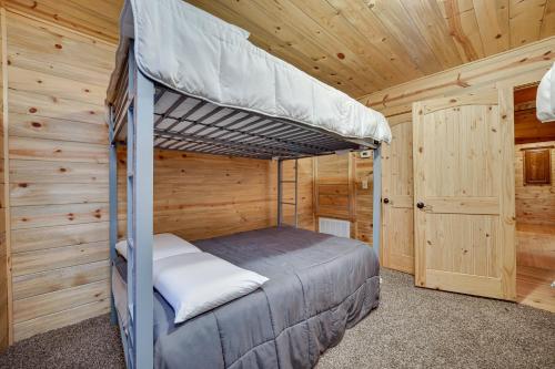 a bedroom with two bunk beds in a wooden cabin at Fort Towson Cabin Less Than 1 Block to Raymond Gary Lake in Fort Towson
