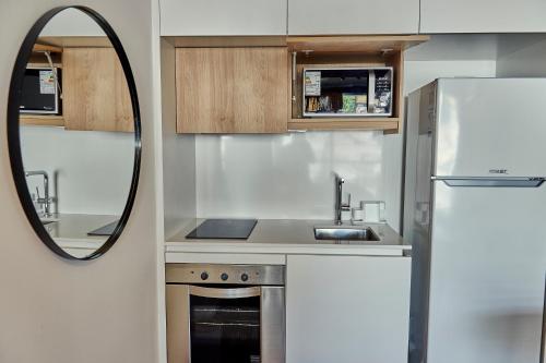 a small kitchen with a sink and a mirror at Babel Arcos in Buenos Aires
