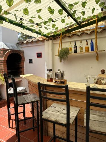 um pátio com um bar com 2 cadeiras e uma mesa em H-OSTELLO LA MERIDIANA em Villa de Leyva