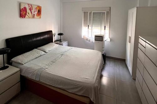 帕特納的住宿－Piso céntrico en Paterna，一间卧室设有一张大床和一个窗户。