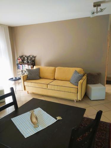 a living room with a yellow couch and a table at Waldwinkel in Treuchtlingen