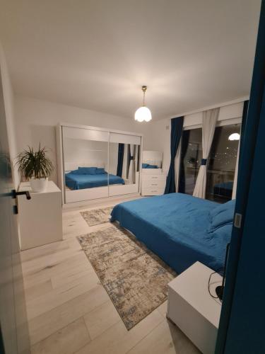um quarto com uma cama azul e um espelho em Sovran's dream 2bedroom Apt 10min wak from center em Pristina