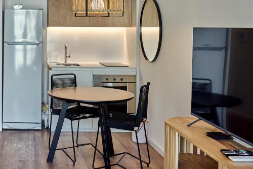 a small kitchen with a table and chairs and a refrigerator at Babel Arcos in Buenos Aires