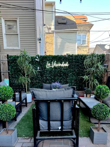 une chaise noire assise dans une cour à côté d'une haie dans l'établissement Chicago-Pilsen Boho apartment with Free parking - Unit C, à Chicago