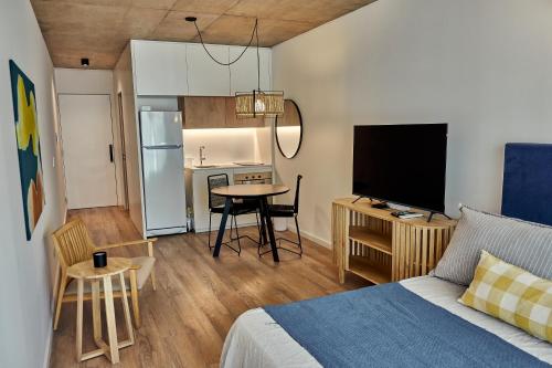 a bedroom with a bed and a kitchen with a table at Babel Arcos in Buenos Aires