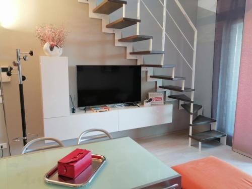 a living room with a tv and a staircase at Appartamento Vivaldi! in Cento