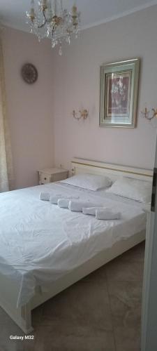 ein großes weißes Bett in einem Schlafzimmer mit einem Kronleuchter in der Unterkunft Даун парк Делюкс in Sonnenstrand