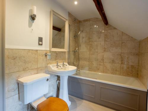 a bathroom with a sink and a toilet and a tub at The Coach House in Greenhaugh