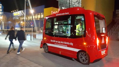 a person walking next to a small red bus at Stockholm Private Rooms in Shared Lovely, Amazing, Modern Apartment +Garden +BBQ in Stockholm