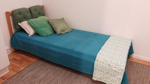 a bed with blue sheets and pillows in a room at Stockholm Private Rooms in Shared Lovely, Amazing, Modern Apartment +Garden +BBQ in Stockholm